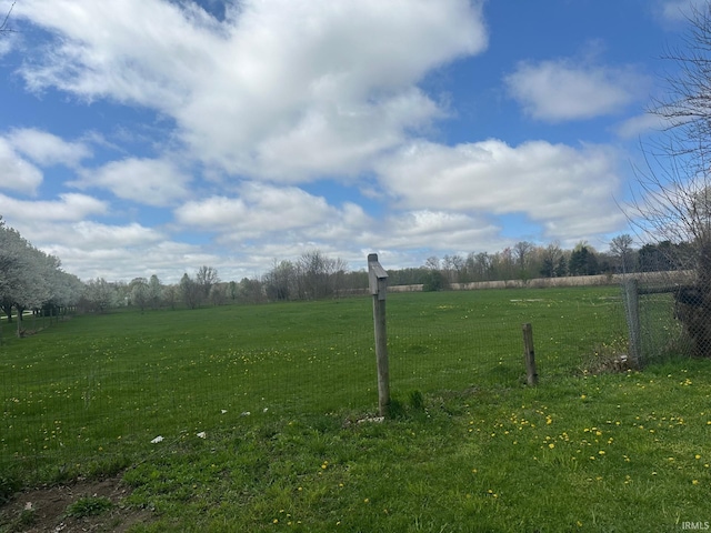 view of yard featuring fence and a rural view