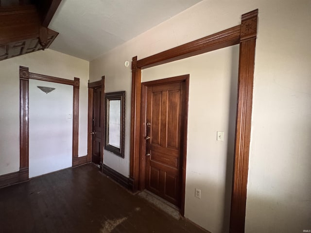 interior space featuring baseboards and dark wood-type flooring