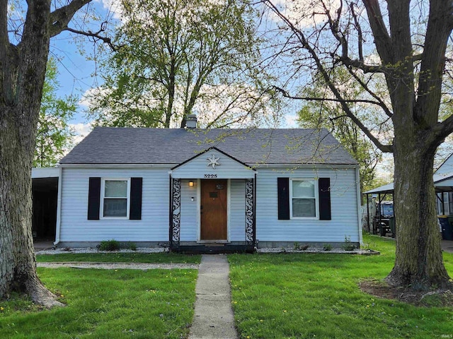 1509 W Glenn Ellyn Dr Unit 9Sfam, Homes Total, Muncie, IN 47304 - bungalow-style house featuring a front lawn, a shingled roof, and a chimney