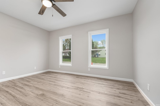 empty room featuring ceiling fan, light wood-style flooring, and baseboards