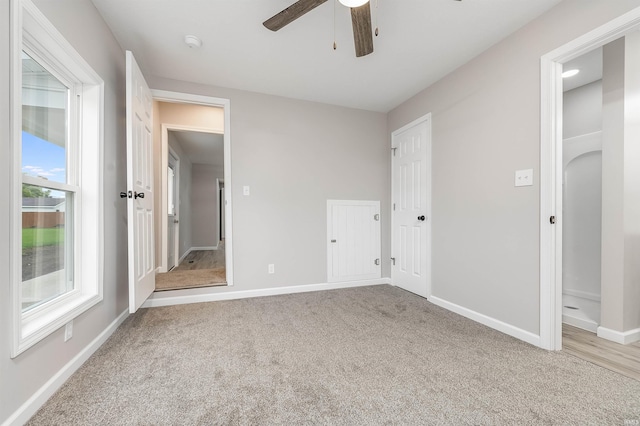 unfurnished bedroom with a ceiling fan, carpet flooring, and baseboards