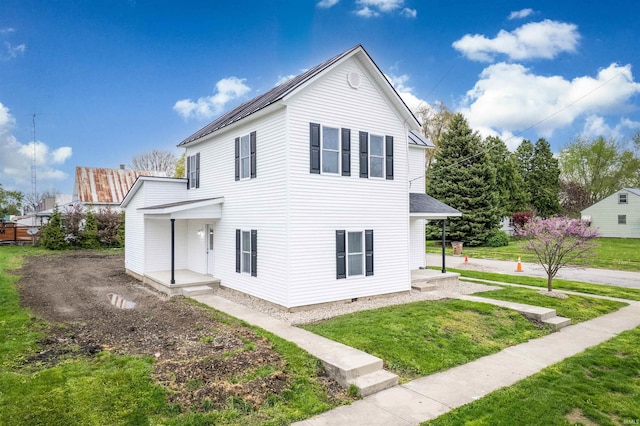 rear view of property featuring a lawn