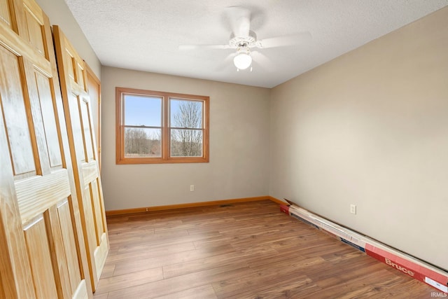 1808 County Road 18th Rd, Waterloo, IN 46793 - unfurnished room featuring baseboards, a ceiling fan, light wood finished floors, and a textured ceiling
