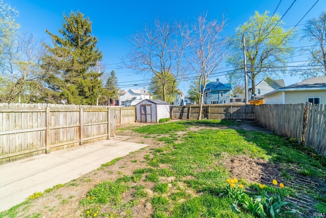 view of yard with a storage unit, an outdoor structure, and a fenced backyard