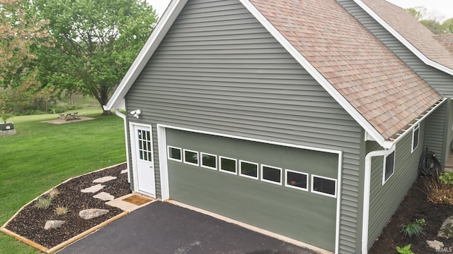 6021 N Timberline Dr, Bloomington, IN 47404 - view of side of property featuring aphalt driveway, a shingled roof, an outbuilding, and a yard