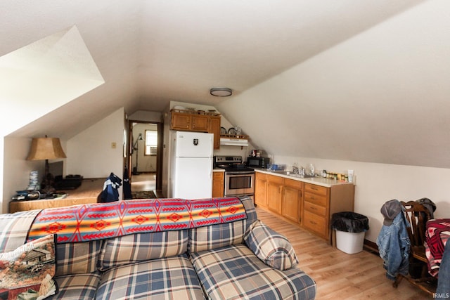 6021 N Timberline Dr, Bloomington, IN 47404 - kitchen with lofted ceiling, light wood-style floors, freestanding refrigerator, under cabinet range hood, and stainless steel electric range
