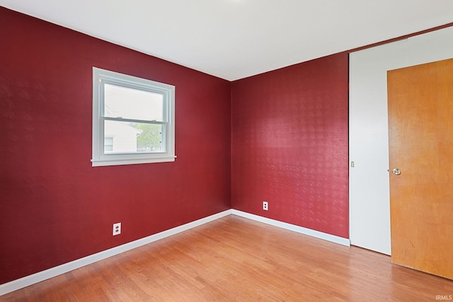 spare room with light wood finished floors and baseboards