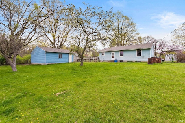 view of yard featuring an outdoor structure and fence