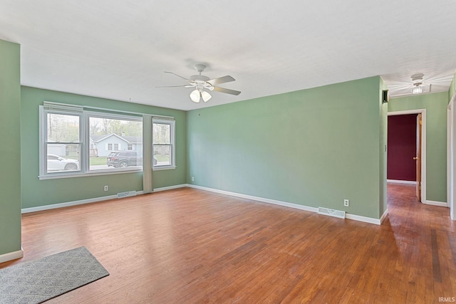 spare room featuring visible vents, wood finished floors, and a ceiling fan