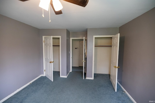 unfurnished bedroom featuring dark colored carpet, two closets, ceiling fan, and baseboards