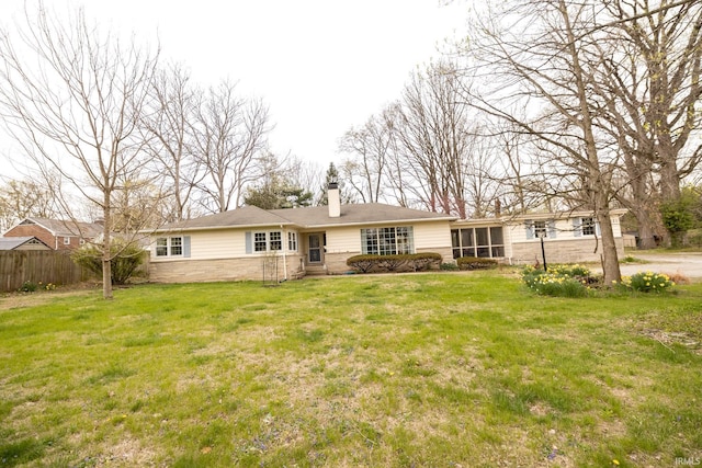 view of front of home featuring fence, a chimney, a front lawn, and stone siding