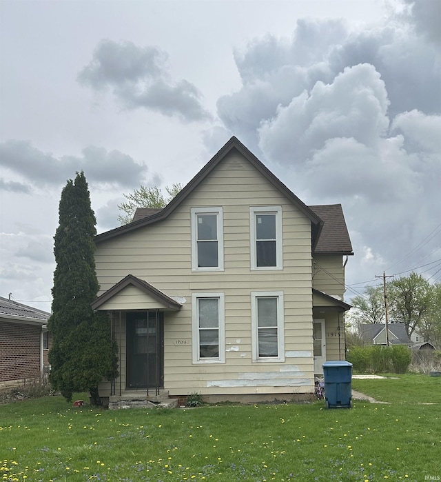 rear view of house featuring a lawn