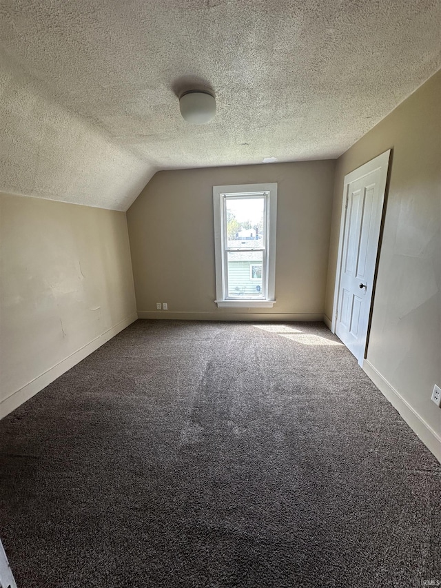 bonus room featuring carpet, baseboards, vaulted ceiling, and a textured ceiling