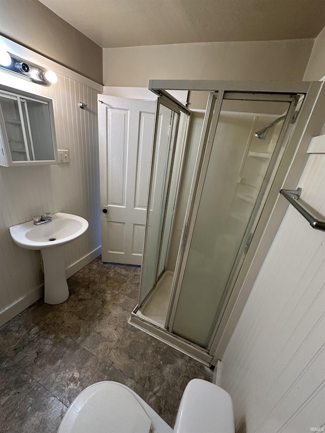 bathroom with a stall shower and toilet
