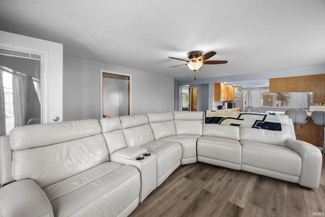 living room with wood finished floors and ceiling fan
