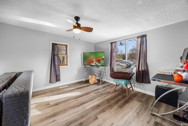 sitting room featuring wood finished floors, baseboards, visible vents, a ceiling fan, and a textured ceiling