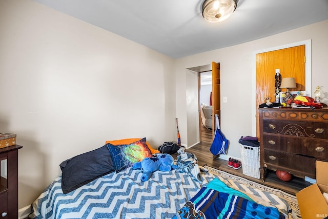 bedroom with baseboards and wood finished floors