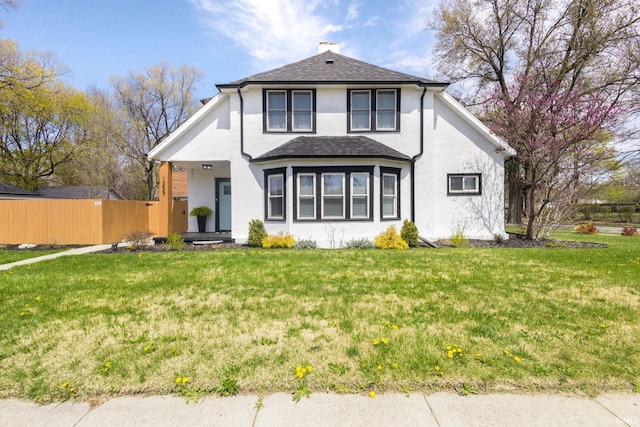 view of front of house featuring a front lawn, a chimney, and fence