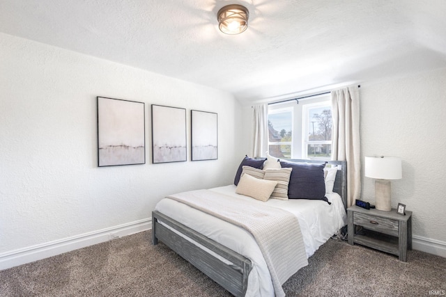 carpeted bedroom with a textured wall and baseboards
