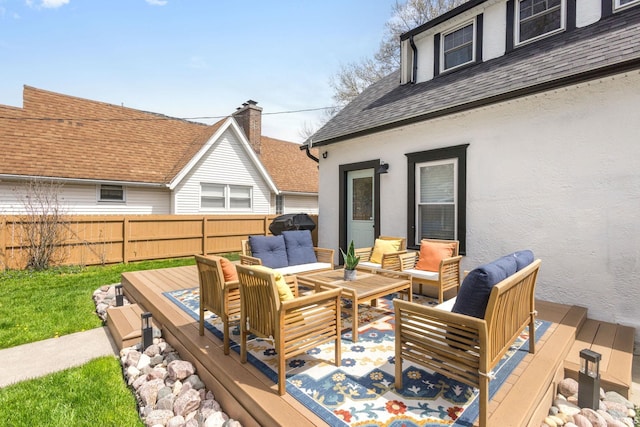 deck with an outdoor living space and a fenced backyard