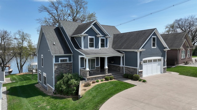 craftsman-style house with covered porch, a garage, driveway, stone siding, and a front yard