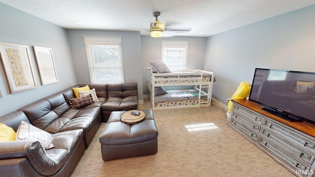 living room with carpet, ceiling fan, and baseboards