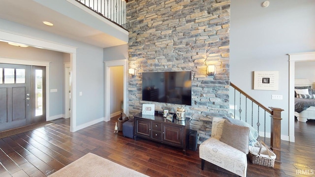 living area with stairway, dark wood finished floors, and baseboards