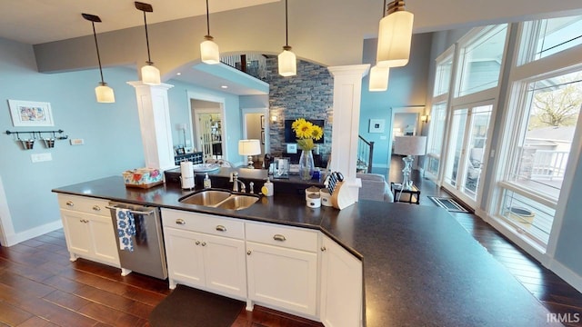 kitchen featuring a sink, dark wood-style flooring, ornate columns, dark countertops, and dishwasher