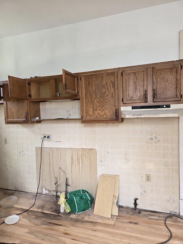 1225 Main St, Vincennes, IN 47591 - kitchen featuring open shelves, under cabinet range hood, wood finished floors, and backsplash