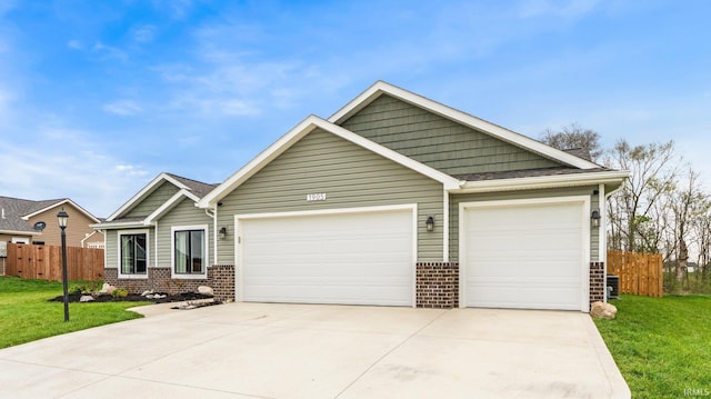 1905 Waynedale Dr, Garrett, IN 46738 - craftsman-style house featuring driveway, fence, an attached garage, and brick siding