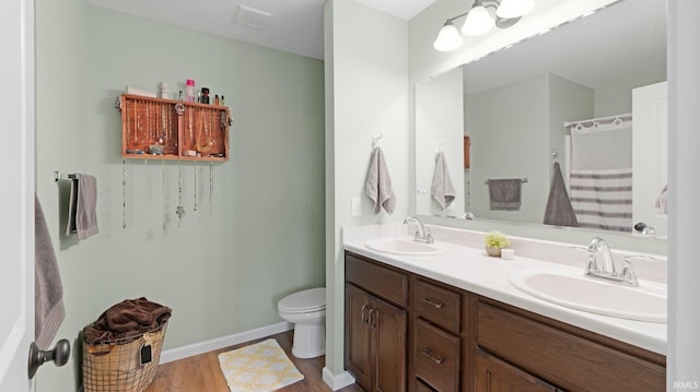 1905 Waynedale Dr, Garrett, IN 46738 - bathroom with wood finished floors, toilet, double vanity, and a sink