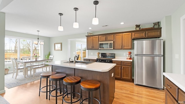 1905 Waynedale Dr, Garrett, IN 46738 - kitchen with brown cabinetry, a sink, stainless steel appliances, and light wood-type flooring