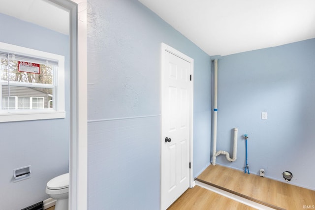 washroom with baseboards, light wood-style flooring, and hookup for a gas dryer