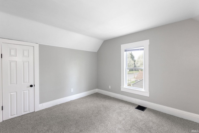 bonus room with carpet flooring, baseboards, vaulted ceiling, and visible vents