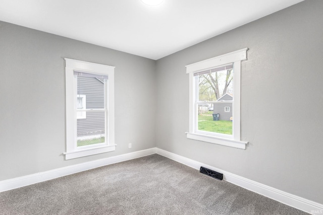 spare room featuring visible vents, carpet floors, and baseboards