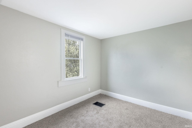 empty room featuring visible vents, light carpet, and baseboards