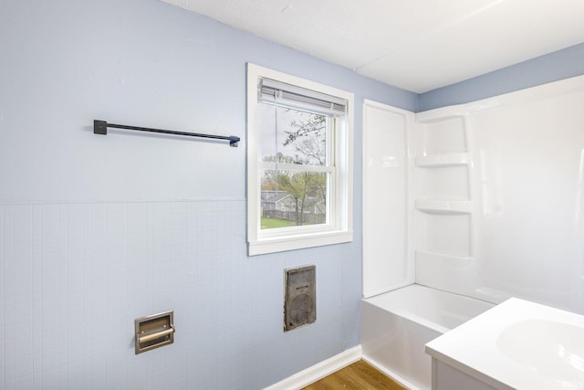 full bath with vanity, baseboards, wood finished floors, and  shower combination