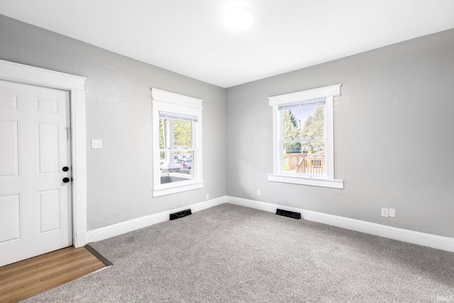 carpeted entrance foyer with visible vents and baseboards