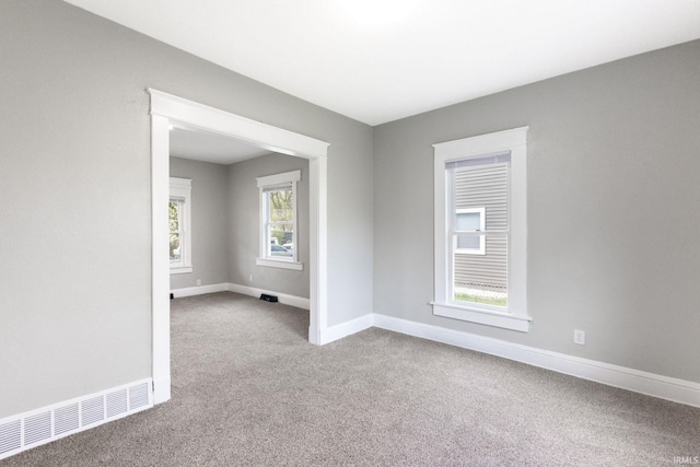 spare room with visible vents, carpet floors, and baseboards
