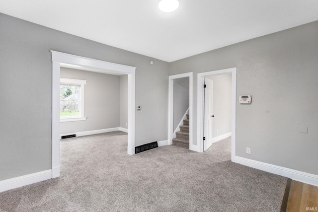 carpeted empty room featuring visible vents and baseboards