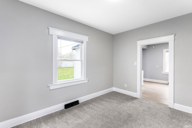 spare room featuring visible vents, carpet floors, and baseboards
