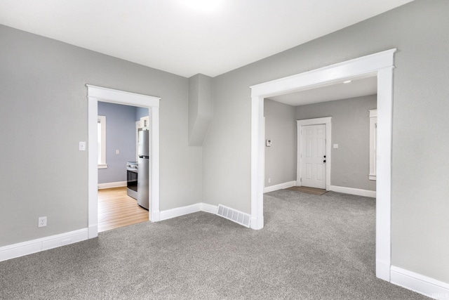 carpeted empty room with visible vents and baseboards