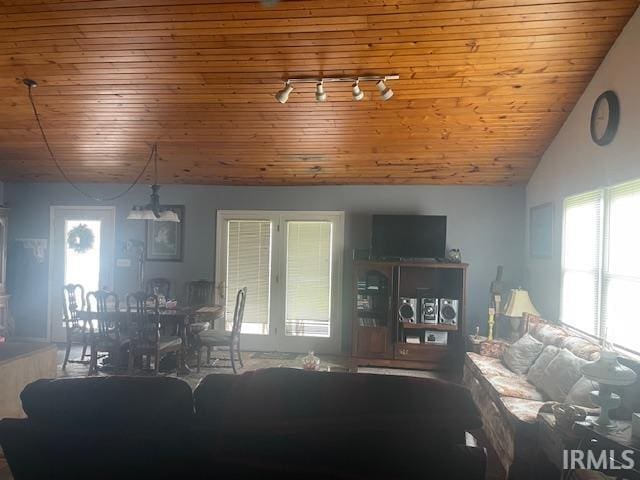 living area featuring a wealth of natural light, vaulted ceiling, and wooden ceiling