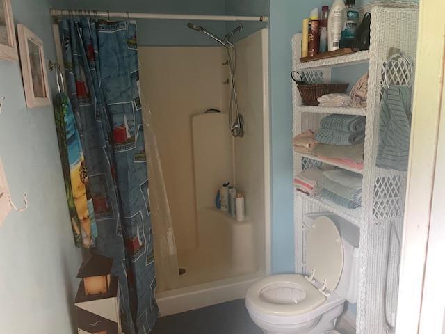 bathroom featuring toilet and a stall shower