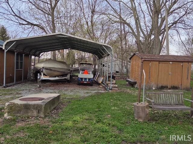 view of vehicle parking with driveway, a detached carport, and a shed