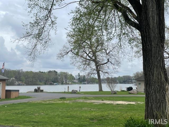 surrounding community with a lawn and a water view