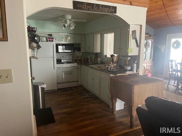kitchen with dark countertops, arched walkways, ceiling fan, and white appliances