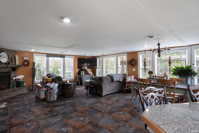 living room featuring a wealth of natural light, a textured ceiling, and a fireplace
