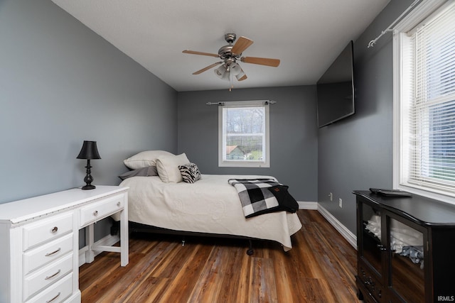 bedroom with dark wood-style floors, ceiling fan, and baseboards