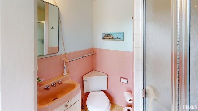 410 Riverside Dr, Jasper, IN 47546 - bathroom with tile walls, a shower stall, toilet, vanity, and wainscoting